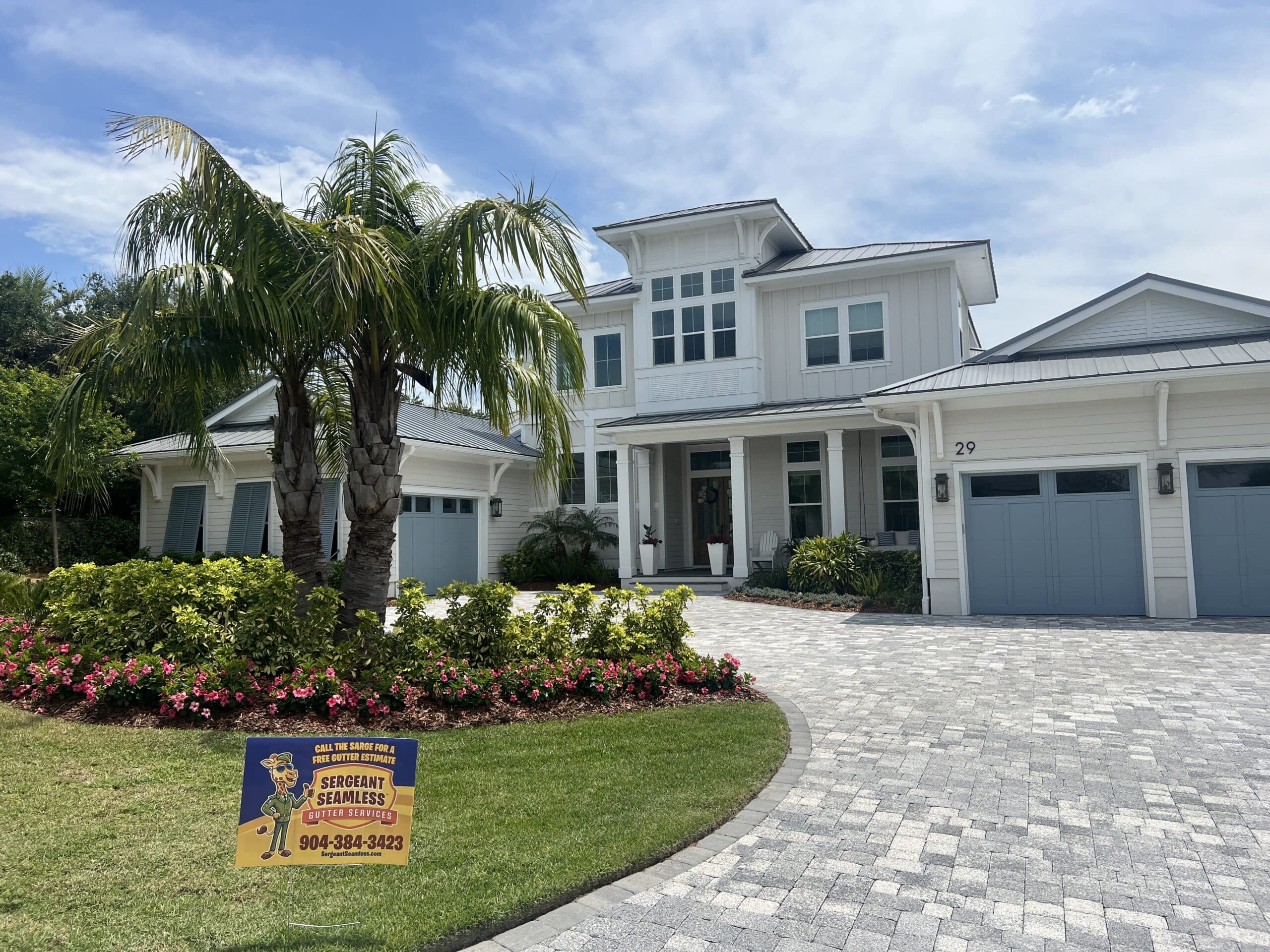 White coastal house with palm trees and driveway