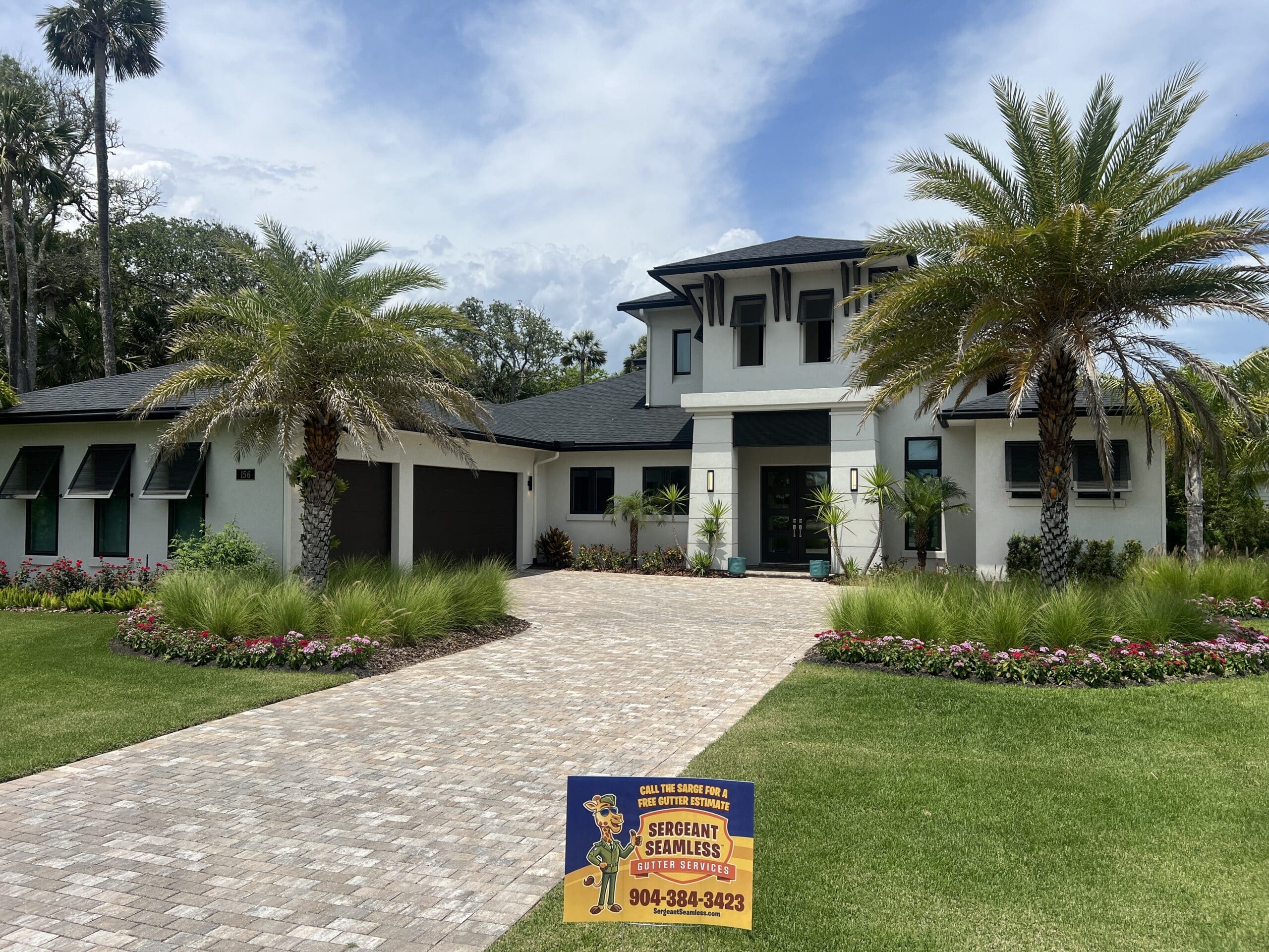 Modern white house with palm trees and driveway