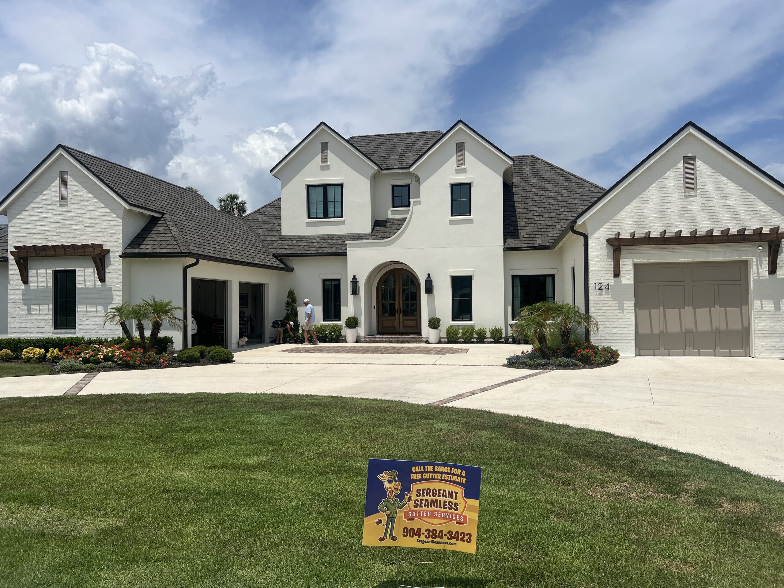 Large white modern house with landscaped yard