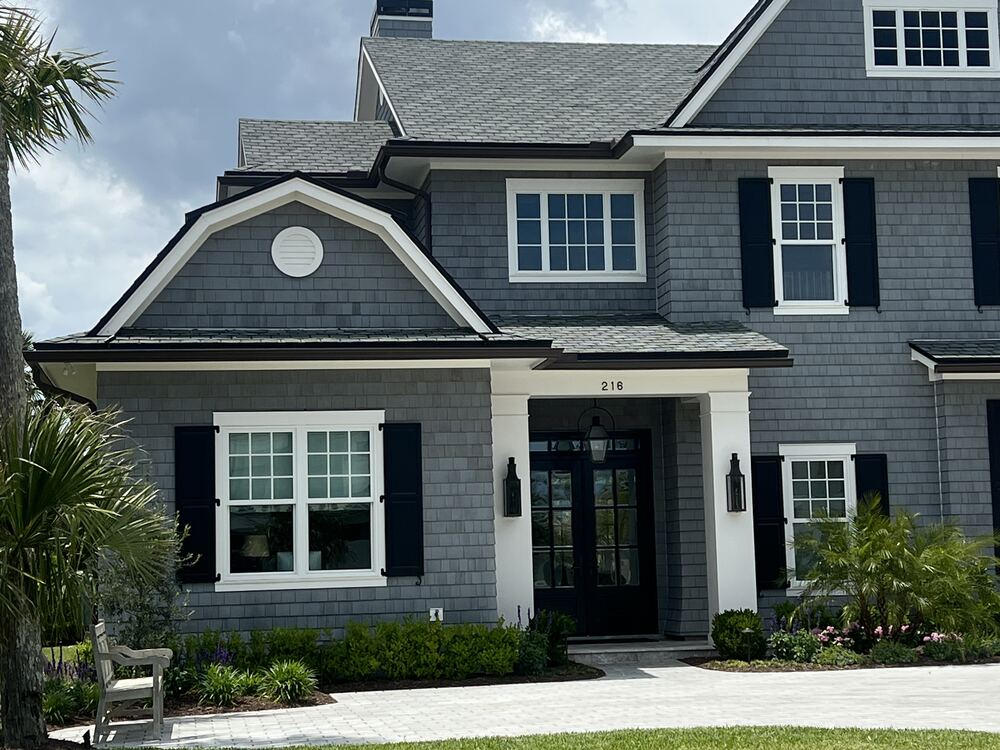 Seamless gutters and downspout on a gray shingle coastal home in Northeast Florida